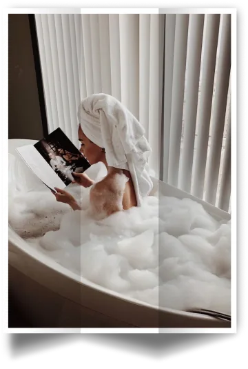 Lifestyle photo from the Galette Skincare social media shoot: woman in a bubble bath with a towel on her head reading a magazine